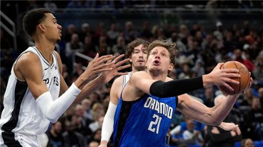 Orlandos Center Moritz Wagner (21) zieht gegen Spurs Center Victor Wembanyama (l) zum Korb.