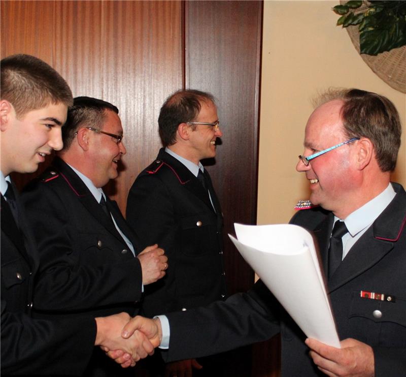 Ortsbrandmeister Günter Meyer (rechts) ernennt Kevin Rothan zum Feuerwehrmann.