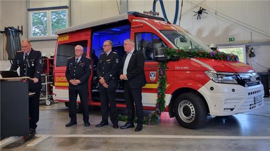 Ortsbrandmeister Malte Hunold begrüßt die Gäste, Claus Rehder, Jens Lohmann und Matthias Riel stehen vor dem neuen Einsatzleitwagen (von links).