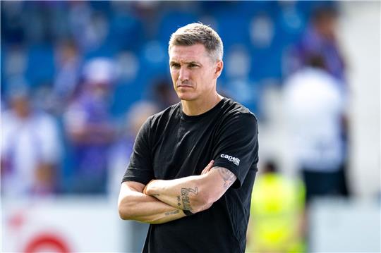 Osnabrücks Trainer Tobias Schweinsteiger beobachtet mit verschränkten Armen das Aufwärmen.