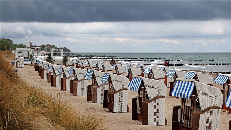 Ostsee: Strandkörbe in Wartestellung – graue Wolken ziehen auf, kaum Menschen am Wasser
