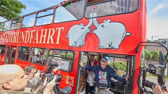 Otto Waalkes, Komiker, steht während der Einweihung eines Ottifanten-Doppeldeckerbusses an den Landungsbrücken in der Tür des Busses.