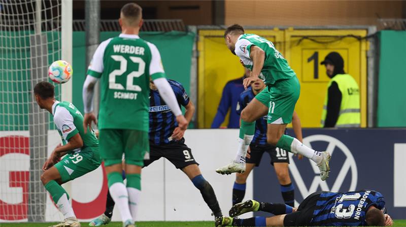 Paderborns Robert Leipertz (r) liegt am Boden, während Bremens Niclas Füllkrug (2.v.r.) ein irreguläres Tor erzielt. Foto: Friso Gentsch/dpa