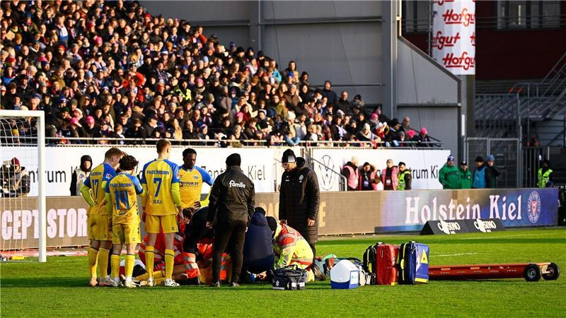Paderborns Spieler Calvin Brackelmann wird auf dem Rasen von Sanitätern behandelt.
