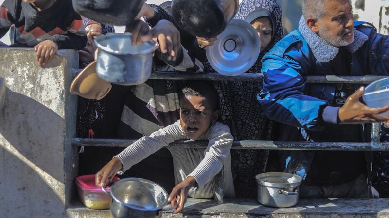 Tel Aviv: UN-Gericht soll Gaza-Antrag Südafrikas ablehnen Palästinenser an einer von einer Wohltätigkeitsorganisation eingerichteten Lebensmittel-Spendenstelle.