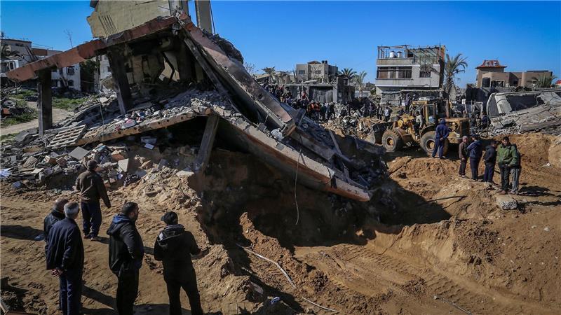 Hamas-Behörde: Mehr als 50.000 Gaza-Tote seit Kriegsbeginn Palästinenser beobachten, wie Mitarbeiter des Zivilschutzes Leichen aus den Trümmern eines durch einen israelischen Luftangriff zerstörten Hauses bergen.