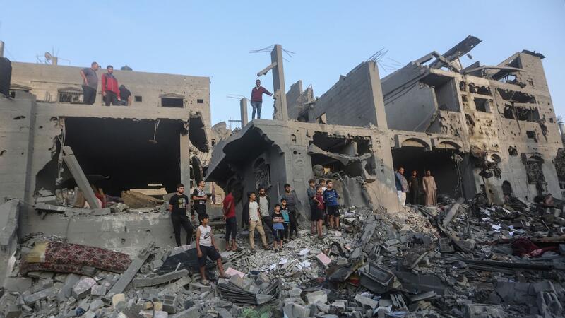 UN beklagen Tausende getötete Kinder im Gazastreifen Palästinenser durchsuchen Gebäude, die bei israelischen Luftangriffen zerstört wurden.