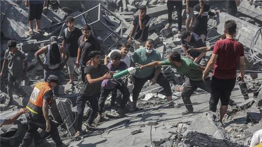 Palästinenser durchsuchen die Trümmer eines Gebäudes in Chan Yunis, das bei einem israelischen Luftangriff zerstört wurde.