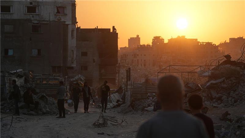 Palästinenser gehen in Gaza-Stadt an Häusern vorbei, die durch die israelische Luft- und Bodenoffensive zerstört wurden.