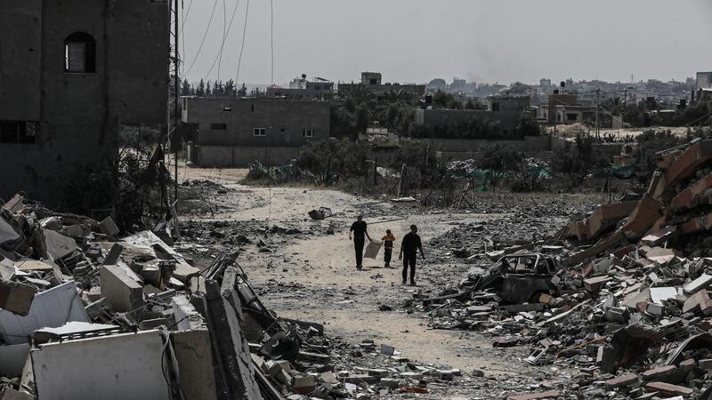 Erneut schwere Kämpfe im Norden Gazas Palästinenser gehen neben zerstörten Wohngebäuden im Lager Nuseirat im zentralen Gazastreifen entlang.