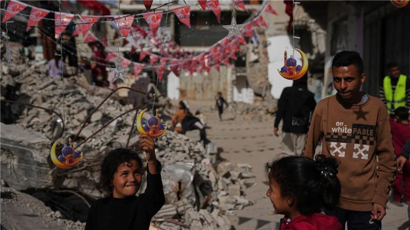Palästinenser hängen Dekorationen neben den Trümmern zerstörter Häuser in Chan Junis auf, während sie sich auf den heiligen Monat Ramadan vorbereiten.