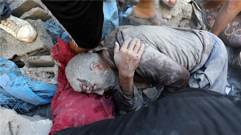 Palästinenser nach dem Angriff auf Gebäude im Flüchtlingsviertel Al-Bureidsch. 