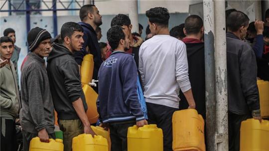 Palästinenser stehen Schlange, um sauberes Wasser aus einer Wasserstation zu erhalten. Die humanitäre Lage in Gaza ist katastrophal.