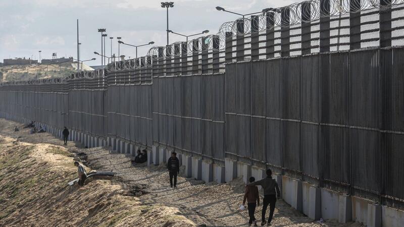 Palästinenser stehen nahe der Grenze zwischen dem Gazastreifen und Ägypten.