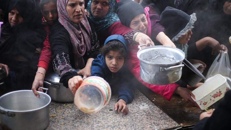 UN-Organisationen: Kinder verhungern im Gazastreifen Palästinenser stehen während der israelischen Luft- und Bodenoffensive für die kostenlose Verteilung von Lebensmitteln an.