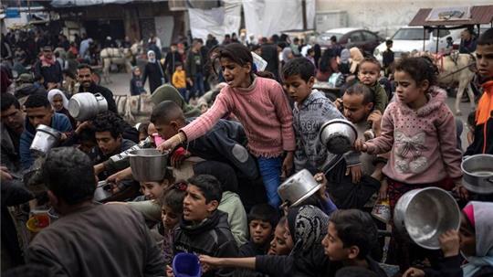 Palästinenser stellen sich in Rafah für eine kostenlose Mahlzeit an.
