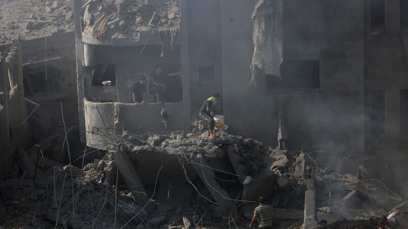 Gaza: Tausende wollen ausreisen - Kliniken kaum arbeitsfähig Palästinenser suchen in den Trümmern eines zerstörten Gebäudes in Bureij nach Überlebenden.