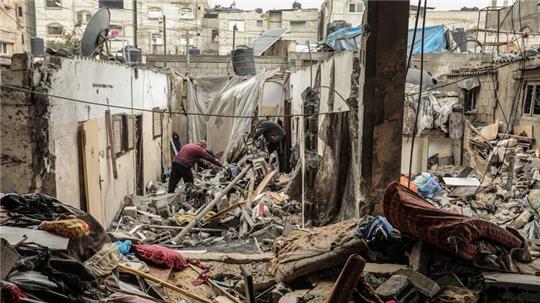 Palästinenser suchen inmitten der Trümmer nach Überresten ihres Besitzes.