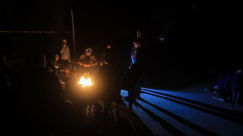 Palästinenser wärmen sich während des vorübergehenden Waffenstillstands an einem Lagerfeuer.