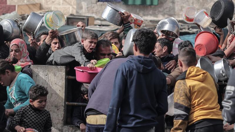 UN-Experten: Israel setzt Hunger als Waffe ein Palästinenser warten an einer Spendenstelle in einem Flüchtlingslager im südlichen Gazastreifen auf Lebensmittel.
