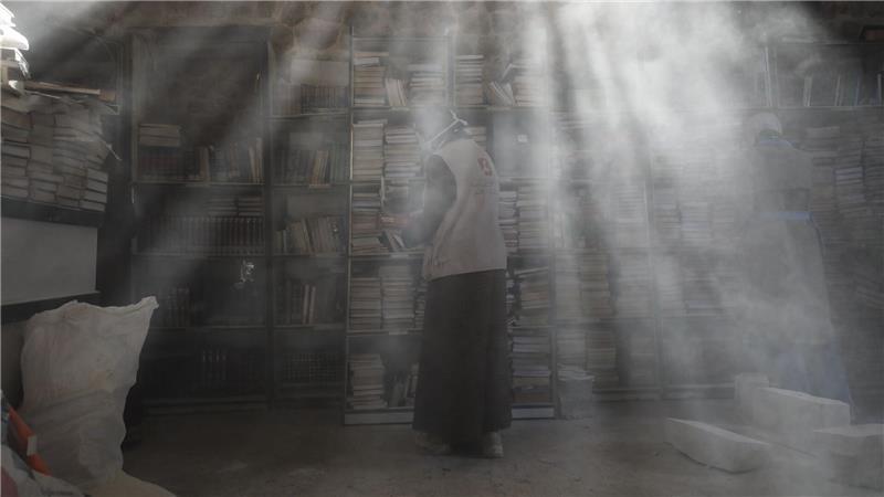 Palästinensische Freiwillige entstauben in der Bibliothek der Großen Omari-Moschee in der Altstadt von Gaza-Stadt Bücher, um beschädigte Bestände nach der zweijährigen Bombardierung des Gazastreifens zu retten und zu restaurieren.