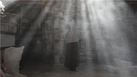 Palästinensische Freiwillige entstauben in der Bibliothek der Großen Omari-Moschee in der Altstadt von Gaza-Stadt Bücher, um beschädigte Bestände nach der zweijährigen Bombardierung des Gazastreifens zu retten und zu restaurieren.