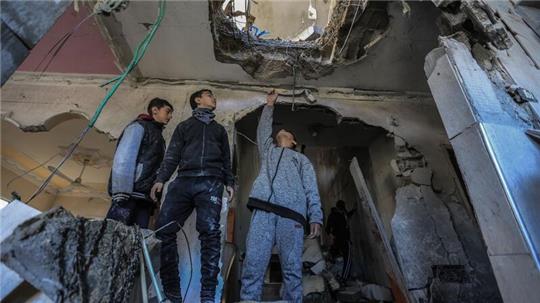 Palästinensische Männer inspizieren in Rafah ein zerstörtes Haus nach einem israelischen Bombardement.