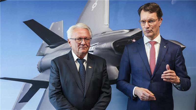 Rheinmetall startet als Zulieferer für Tarnkappenbomber Papperger und Wüst vor einem Bild des F-35-Flugzeugs. Ende nächsten Jahres soll das erste Rumpfmittelteil dieses Tarnkappenbombers in Weeze fertig sein.
