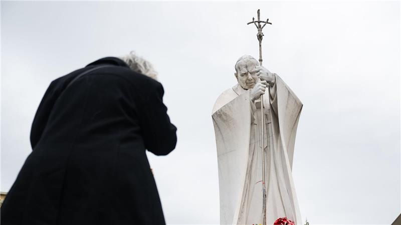 Papst Franziskus im Krankenhaus: eine Frau betet unter der Statue von Papst Johannes Paul II. vor der Poliklinik Agostino Gemelli.