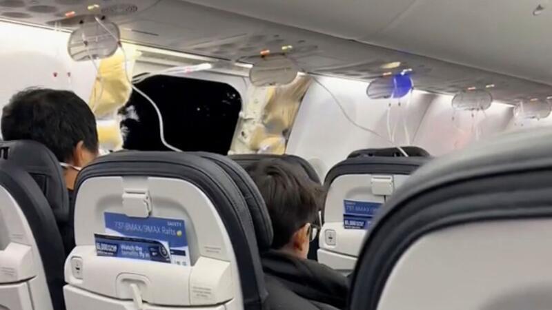 Kabinenteil im Flug abgerissen - Boeings am Boden Passagiere sitzen in der Boeing 737-9 Max in der Nähe des abgerissenen Kabinenteils samt Fenster.