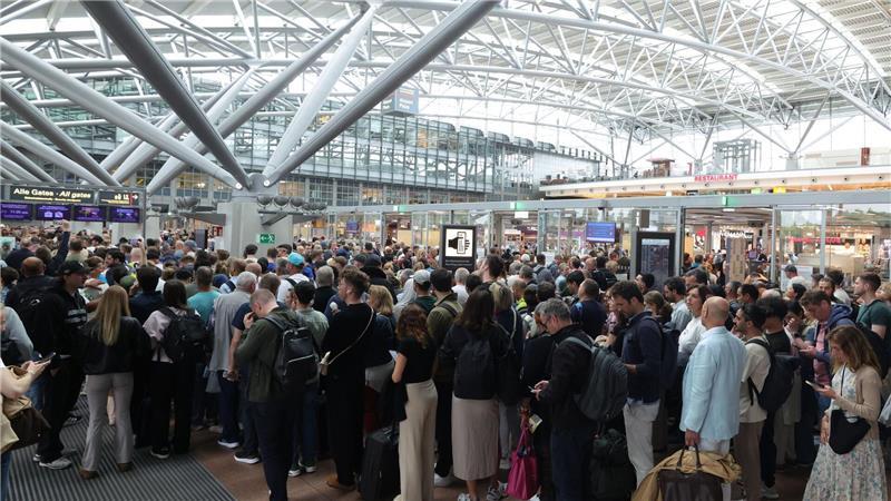 Passagiere stehen vor der Sicherheitskontrolle am Hamburger Flughafen. (Archivbild.)