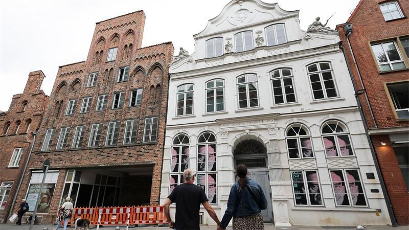 Passanten betrachten das geschlossene Buddenbrookhaus in der Lübecker Altstadt.
