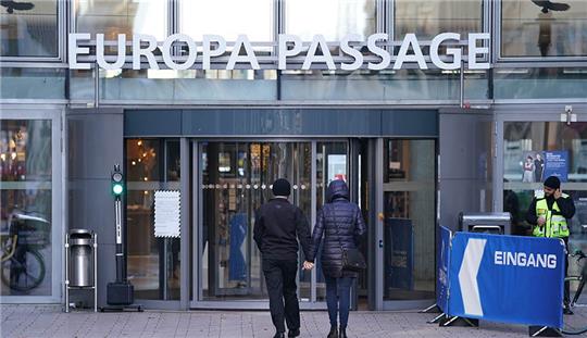 Passanten gehen an einer grünen Ampel am Eingang des Einkaufszentrums Europapassage vorbei. Ein junger Mann ist am Freitagabend in der Europapassage mit einem Messer attackiert und lebensgefährlich verletzt worden. Foto: Marcus Brandt/dpa