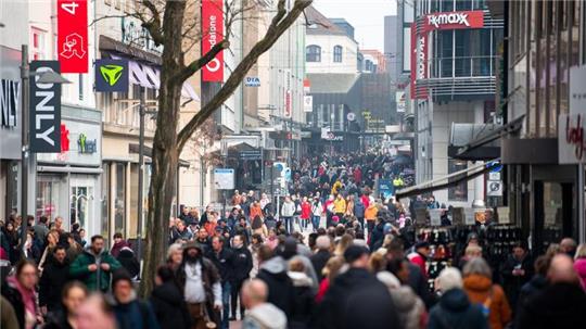 Passanten gehen während des verkaufsoffenen Sonntags durch die Innenstadt.