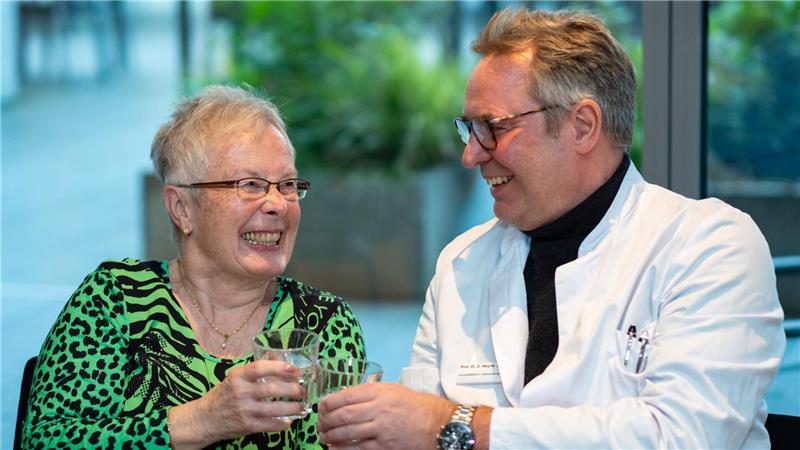 Patientin Antonie Deussen (l) stößt mit Klinikdirektor Dirk Weyhe vom Pius-Hospital Oldenburg auf eine gelungene Krebsoperation an. Die Patientin hat an einer Studie mit Holomedizin teilgenommen.