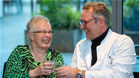 Patientin Antonie Deussen (l) stößt mit Klinikdirektor Dirk Weyhe vom Pius-Hospital Oldenburg auf eine gelungene Krebsoperation an. Die Patientin hat an einer Studie mit Holomedizin teilgenommen. 