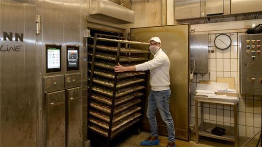 Patrick Fiedler bestückt einen Räucherofen in der Firma.