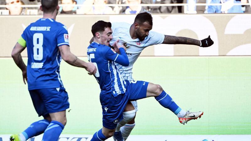 Niederlechner-Dreierpack für Hertha - Paderborn siegt spät Paul Nebel (l) vom KSC und der Rostocker Torschütze zum 1:0, Junior Brumado, im Zweikampf.
