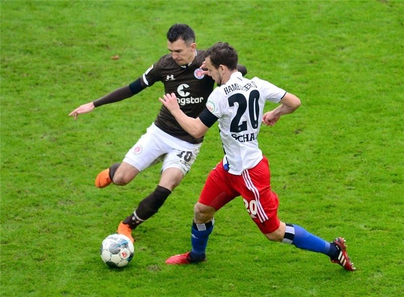 Paulis Waldemar Sobota (l) und Hamburger SVs Louis Schaub kämpfen um den Ball. Foto: Daniel Bockwoldt/dpa