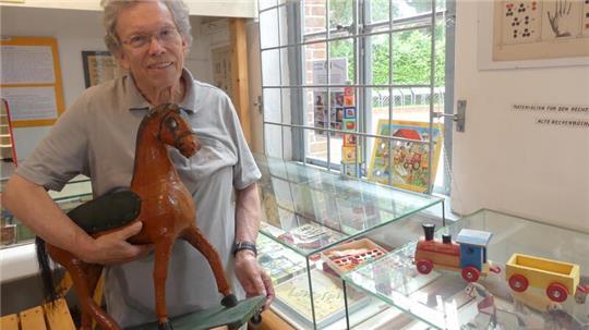 Peter Carsten vom Heimat- und Schulmuseum zeigt ein Exponat der Spielzeugausstellung.