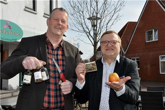 Peter Schleßelmann (links) mit drei Sorten Apfelgeist in der Hand, den es unter anderem bei Gretchens gibt, und Peter Hoffmann mit einem Hornbörger Pannkoken wollen Wissen über alte Obstsorten sammeln. Foto: Lankuttis