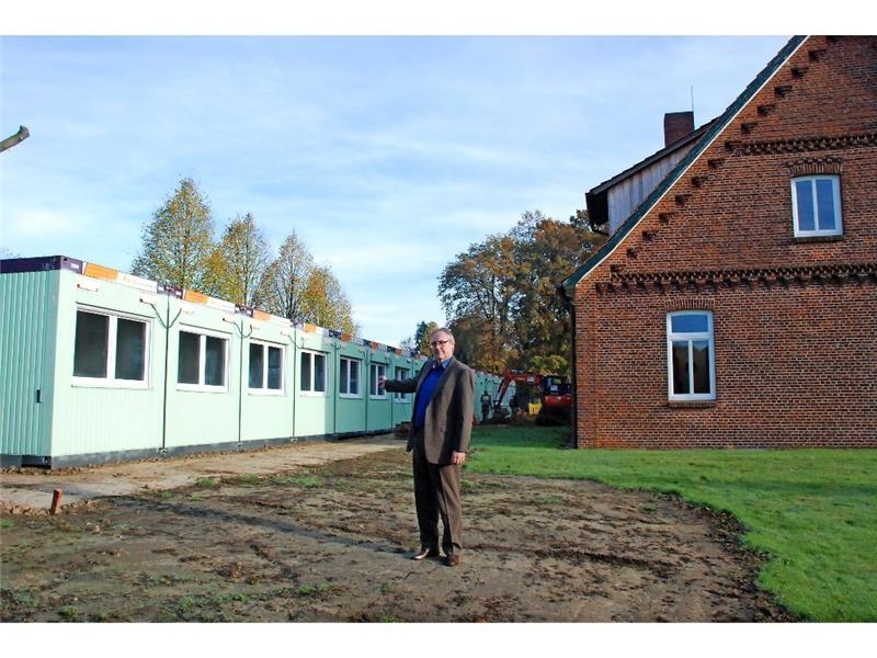 Peter Sommer zeigt auf die Containeranlage hinterm Rathaus in Apensen. Hier sollen in Zweibett-Zimmern insgesamt 26 Flüchtlinge unterkommen.