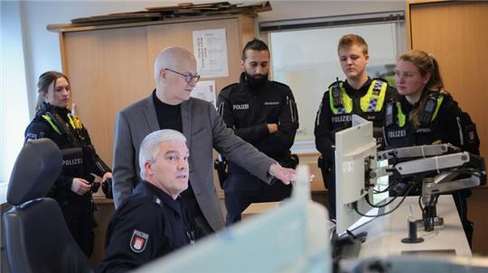 Peter Tschentscher (3.v.l.) unterhält sich mit den wachhabenden Beamten im Polizeikommissariat 26 in Hamburg-Osdorf.