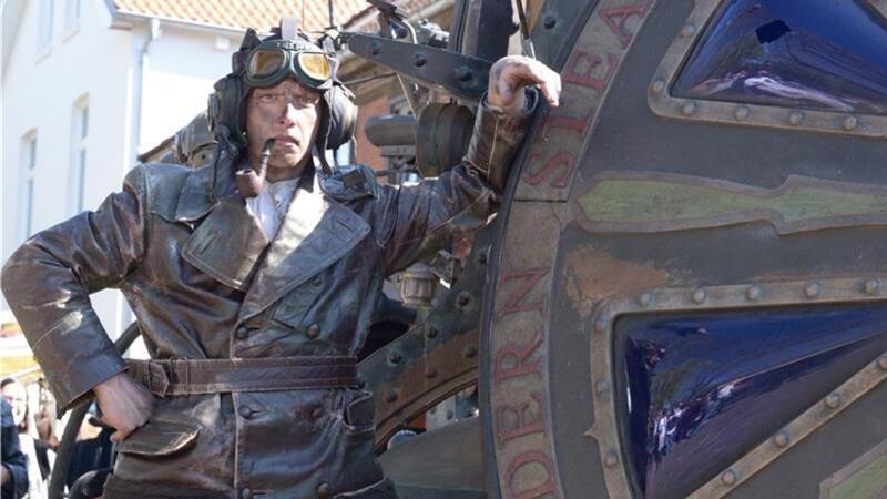 Peter Wessels steht lässig an seinem Hochrad. Er gehörte beim Steampunk-Festival 2023 zur Abacus Theatergruppe aus den Niederlanden.