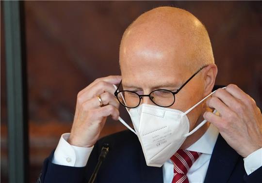 Peter Tschentscher (SPD), Erster Bürgermeister, setzt sich nach der Landespressekonferenz (LPK) eine FFP2-Maske auf. Foto: Marcus Brandt/dpa
