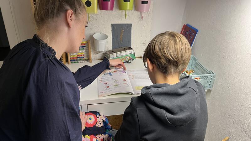 Pflegemutter Anne Knütel unterstützt ihren Pflegesohn Till (Name geändert) bei den Hausaufgaben.