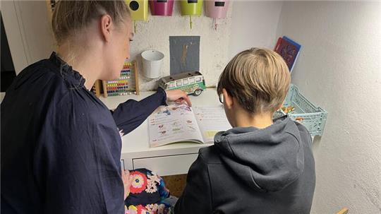 Pflegemutter Anne Knütel unterstützt ihren Pflegesohn Till (Name geändert) bei den Hausaufgaben.