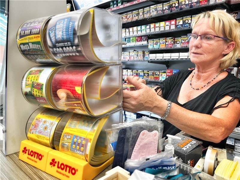 Pflück das Glück oder Mega Money heißen die Rubbellose, von denen Marion Boje gerade eins abreißt. Sie spielt im Kiosk oft Glücksfee. Fotos: Richter