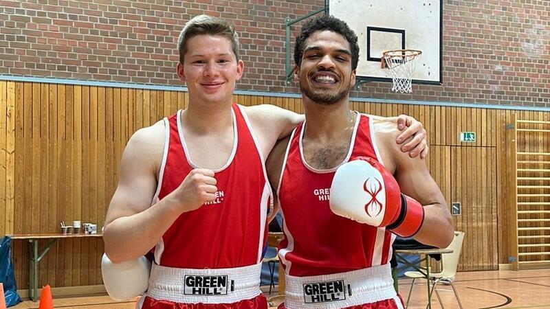 BSV-Boxer zu stark für die Gegner Die in rot gekleideten Boxer Philipp Bergmeyer und Ama Amadi ballen eine Faust und lächeln in die Kamera.