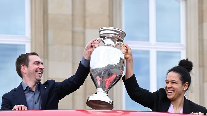 Philipp Lahm, Turnierdirektor der Fußball-Europameisterschaft, hält zusammen mit der früheren Fußball Nationalspielerin Celia Sasic den EM-Pokal hoch.
